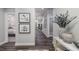 A hallway with dark wood floors, a decorative vase, artwork, and an open view into the adjacent living area at 153 Tennyson Dr # 235, Garner, NC 27529