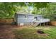 Exterior view of a home with a small deck, stairs, and a large backyard with a fire pit at 1615 Malta Ave, Raleigh, NC 27610