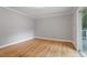 Bright bedroom with hardwood floors and sliding door access to a private balcony at 1615 Malta Ave, Raleigh, NC 27610