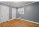 Bedroom features a window, hardwood floors, neutral paint, and white trim at 1615 Malta Ave, Raleigh, NC 27610