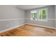 Bedroom with window, hardwood floors, neutral paint and white trim at 1615 Malta Ave, Raleigh, NC 27610