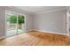 Bright bedroom with hardwood floors and sliding door access to a private balcony at 1615 Malta Ave, Raleigh, NC 27610