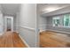 Hallway leading to a bathroom and bedroom with hardwood floors at 1615 Malta Ave, Raleigh, NC 27610