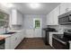 Well-lit kitchen with modern appliances, granite countertops, and dark wood flooring at 1615 Malta Ave, Raleigh, NC 27610
