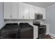 Clean, organized kitchen area with white cabinetry, stainless steel appliances, and stacked washer dryer combo at 1615 Malta Ave, Raleigh, NC 27610