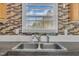 Close-up of kitchen sink featuring stone-look countertops, stainless fixtures, and colorful backsplash at 162 E Abbey Ct, Smithfield, NC 27577