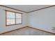 Well-lit bedroom featuring neutral carpeting, trim and a window at 1635 Sandy Cross Rd, Burlington, NC 27217