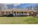 Charming red brick ranch-style home with white front porch, situated on a beautiful lawn at 1635 Sandy Cross Rd, Burlington, NC 27217