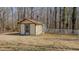 Quaint outbuilding with a chimney and white picket fence nestled among trees at 1635 Sandy Cross Rd, Burlington, NC 27217