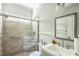 Bathroom featuring a shower with glass doors, tile surround, and a vanity with decorative mirror at 1900 High Oaks Ln, Raleigh, NC 27606