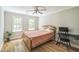 Cozy bedroom featuring hardwood floors, a ceiling fan, and natural light from two windows at 1900 High Oaks Ln, Raleigh, NC 27606