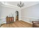 Elegant dining room with decorative moldings, hardwood floors, and an antique dresser with a chandelier at 1900 High Oaks Ln, Raleigh, NC 27606
