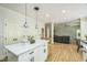 Kitchen island with white countertops, bar seating, and open floor plan to living room at 1900 High Oaks Ln, Raleigh, NC 27606