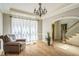Living room featuring hardwood floors, a decorative chandelier, and access to a staircase at 1900 High Oaks Ln, Raleigh, NC 27606
