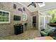 Relaxing brick patio with seating, a TV, and a fan; ideal for outdoor entertainment and leisure at 1900 High Oaks Ln, Raleigh, NC 27606