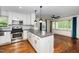 Modern kitchen with stainless steel appliances, gray countertops, and a view of the living room area at 200 Lincoln Ct, Raleigh, NC 27610