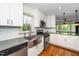 Modern kitchen features stainless steel appliances, farmhouse sink, white cabinets, and hardwood floors at 200 Lincoln Ct, Raleigh, NC 27610