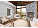 A cozy screened porch featuring an egg chair, decorative fireplace and tile, and wood flooring provides indoor/outdoor living at 200 Lincoln Ct, Raleigh, NC 27610