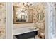 Elegant bathroom with a clawfoot tub, decorative wallpaper, ornate mirror, and chandelier lighting at 2004 Riverview Dr, Clayton, NC 27527