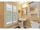 Bright bathroom featuring a pedestal sink, large window with shutters, and a tiled floor at 2004 Riverview Dr, Clayton, NC 27527