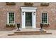 Close up of a brick home's main entrance with black door, flower boxes, and black urns at 2004 Riverview Dr, Clayton, NC 27527