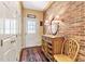 Welcoming hallway featuring hardwood floors, a brick wall, and a storage cabinet at 2004 Riverview Dr, Clayton, NC 27527