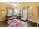 Cozy home office with wood floors, a ceiling fan, traditional desk, and sunny windows with decorative valances at 2004 Riverview Dr, Clayton, NC 27527