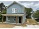 View of home with blue siding, front porch, manicured lawn and newly installed wood fence at 207 Sallinger St, Knightdale, NC 27545