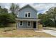 Charming two-story home featuring blue siding, a welcoming front porch, and manicured lawn at 207 Sallinger St, Knightdale, NC 27545