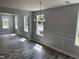 Bright living room with many windows, decorative trim, wood-look flooring and chandelier at 207 Sallinger St, Knightdale, NC 27545
