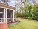 Backyard view featuring a screened-in porch and lush landscaping with a stone pathway at 21 Kimberly Dr, Durham, NC 27707