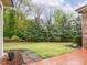 Landscaped backyard featuring a brick patio, grass, and manicured trees and shrubs at 21 Kimberly Dr, Durham, NC 27707