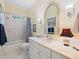 Bathroom showcasing marble countertop, decorative vanity, tub with shower, and tiled walls at 21 Kimberly Dr, Durham, NC 27707