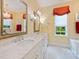 Bright bathroom boasts double sink vanity with marble countertops and decorative mirrors at 21 Kimberly Dr, Durham, NC 27707