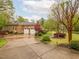 Long, paved driveway leading to a brick home with a two-car garage and landscaped surroundings at 21 Kimberly Dr, Durham, NC 27707