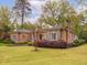 Brick home featuring blue shutters, a well-maintained lawn, and mature landscaping at 21 Kimberly Dr, Durham, NC 27707
