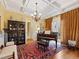 Elegant living room featuring a piano, coffered ceiling, decorative rug, and ample natural light at 21 Kimberly Dr, Durham, NC 27707