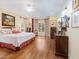 Spacious main bedroom features hardwood floors, ceiling fan, and bedside tables for ambient lighting at 21 Kimberly Dr, Durham, NC 27707