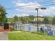 Scenic view of the tennis courts at Hope Valley Country Club with trees and green grass at 21 Kimberly Dr, Durham, NC 27707