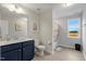 Well-lit bathroom with a single vanity, toilet and shower with curtain and a window at 211 Tobacco Barn Dr, Angier, NC 27501