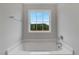 Bright bathroom with a soaking tub and window view of the green trees at 211 Tobacco Barn Dr, Angier, NC 27501