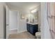 View of the bathroom with navy blue vanity, mirror, toilet and tiled floors at 211 Tobacco Barn Dr, Angier, NC 27501