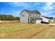 Gray two-story home with a well-maintained lawn, wooden fence, and a convenient two-car garage at 211 Tobacco Barn Dr, Angier, NC 27501