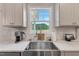 Close up view of kitchen sink, counter, and window with stainless steel appliances and white cabinets at 211 Tobacco Barn Dr, Angier, NC 27501