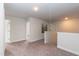 Carpeted upstairs hallway with neutral walls and white trim, offering access to various rooms at 215 Kipling Creek Dr, Fuquay Varina, NC 27526
