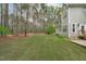 Lush backyard featuring a green lawn with mature trees at 2408 Merion Creek Dr, Apex, NC 27539