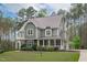 Charming two-story home with a welcoming front porch and beautifully landscaped front yard surrounded by mature trees at 2408 Merion Creek Dr, Apex, NC 27539