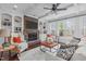 Bright living room features a stone fireplace, built-in shelves, and tray ceiling at 2408 Merion Creek Dr, Apex, NC 27539