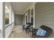Inviting porch with wicker chairs, a table and a view to the home's serene setting at 2408 Merion Creek Dr, Apex, NC 27539
