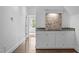 Stylish wet bar featuring granite countertops and attractive tile backsplash at 2408 Merion Creek Dr, Apex, NC 27539